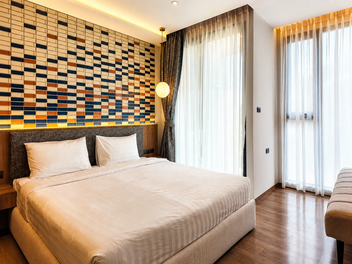 Suite bedroom with mosaic feature wall at Bellevue Beachfront