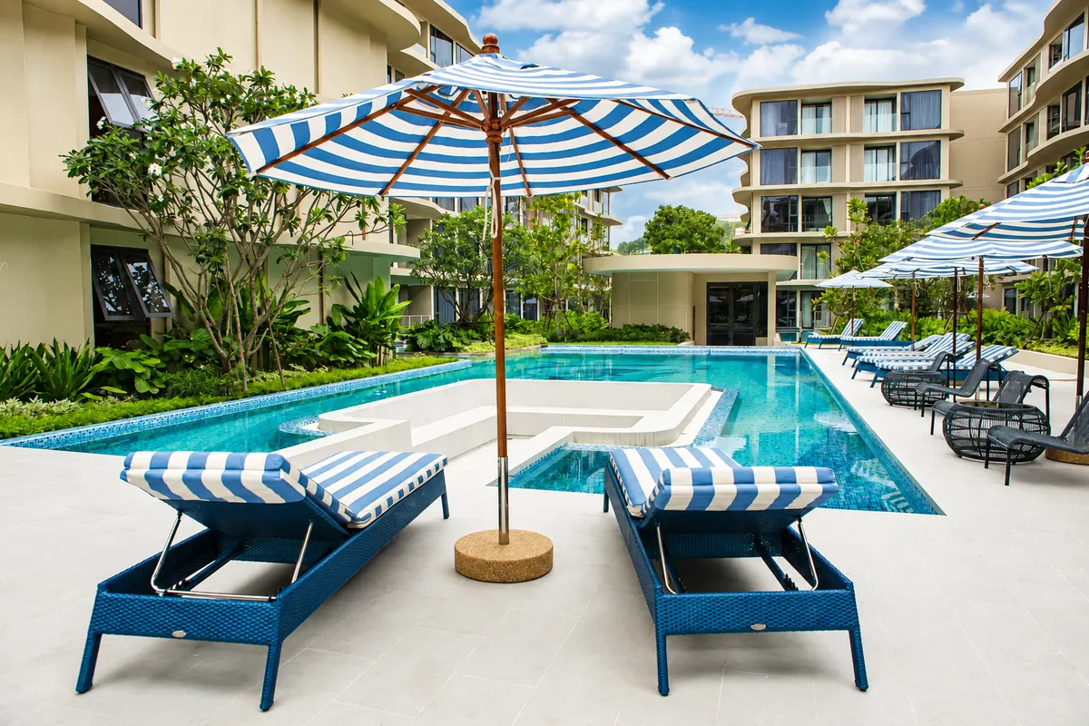 Pool deck with loungers and parasols at Bellevue Beachfront